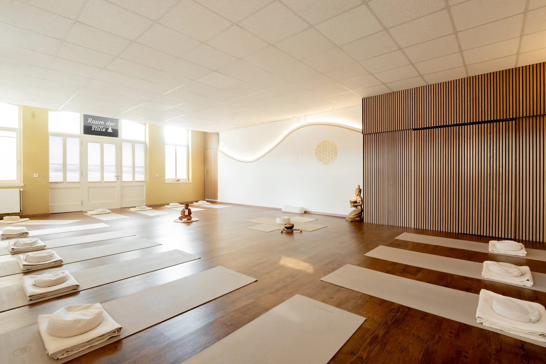 Der vorbereitete Yogaraum der Me-Yo Akademie mit Matten und Meditationskissen.